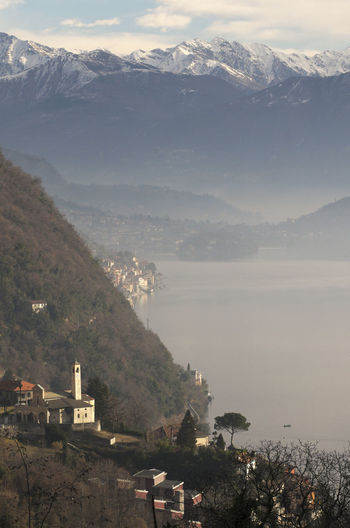 High angle view of town by sea against sky