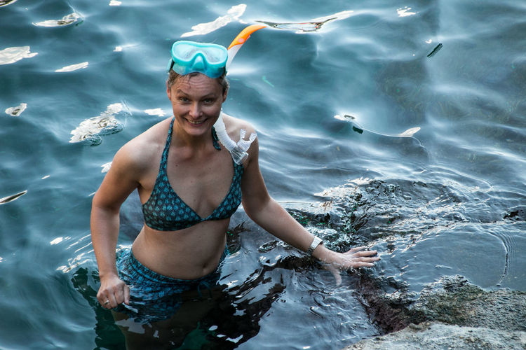 Portrait of smiling young woman snorkeling in sea