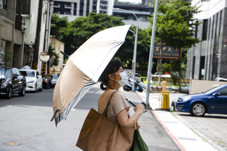Rear view of man with umbrella on street
