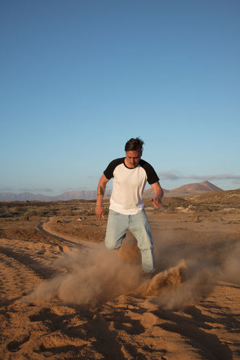 Full length of young man standing on desert