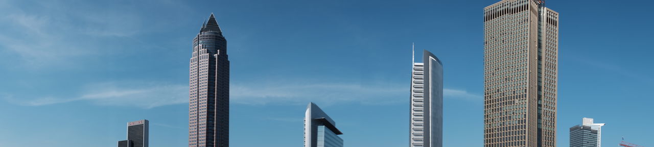 Panoramic view of skyscrapers against blue sky
