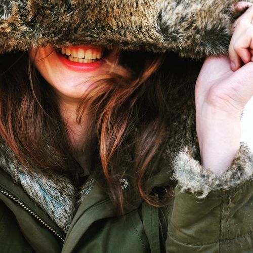 Close-up of woman laughing in hooded jacket