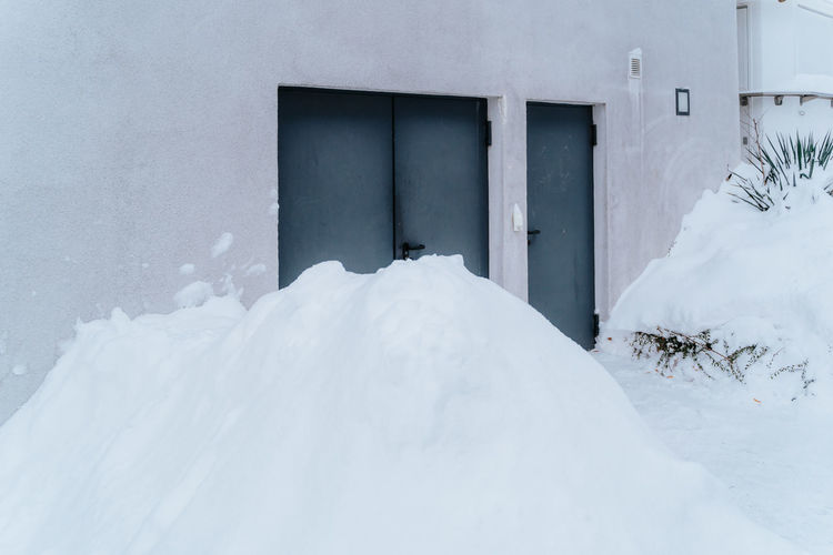 Huge piles of snow covering doors and gates of houses