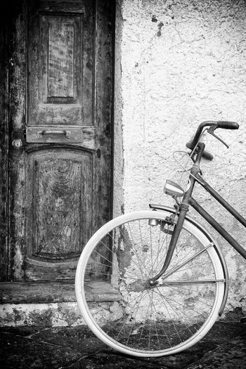Bicycle leaning on wall of building