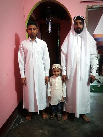 Portrait of family standing in traditional clothing at home