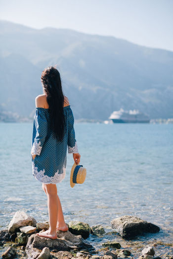Rear view of young woman standing at beach