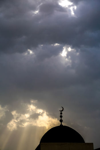 Low angle view of weather vane against sky