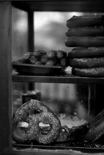 Close-up of churro and pretzel in display cabinet for sale
