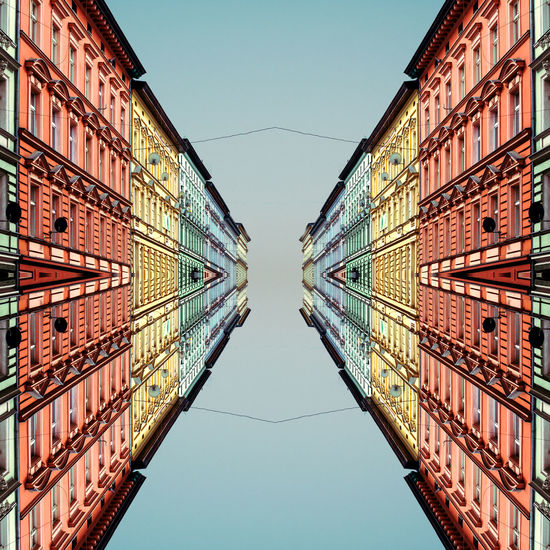 Reflection of buildings in water against clear sky