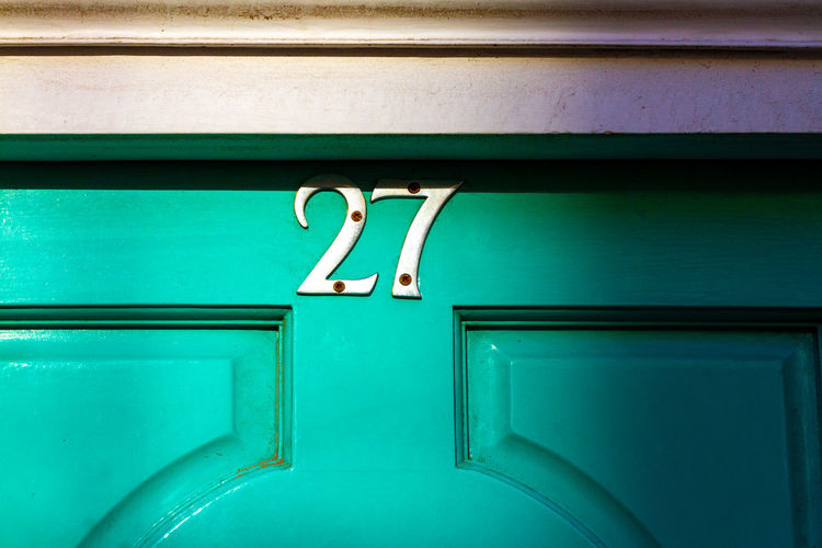House number 27 on a wooden front door 