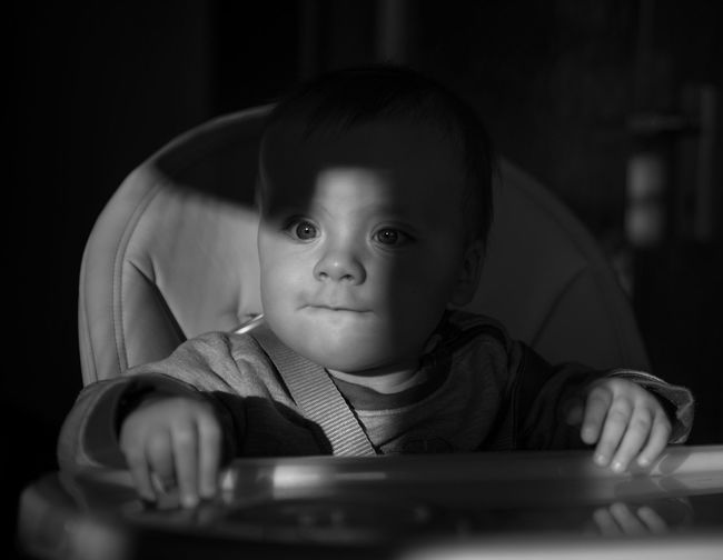 Close-up of cute baby boy sitting on chair
