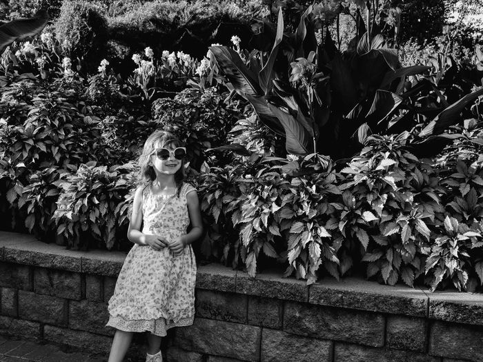 Portrait of girl standing by plants