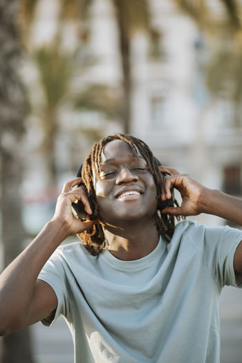 Happy man listening music through headphones