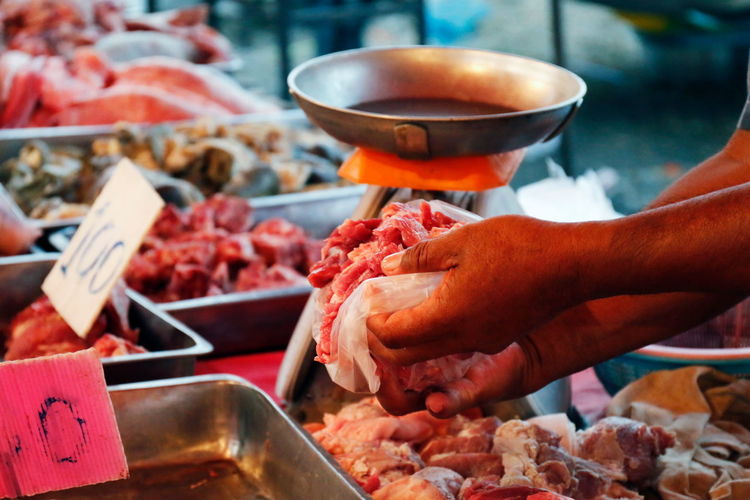 Cropped image of butcher selling meat at market