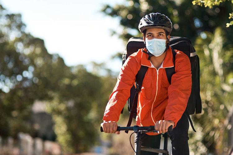 Man wearing mask riding bicycle