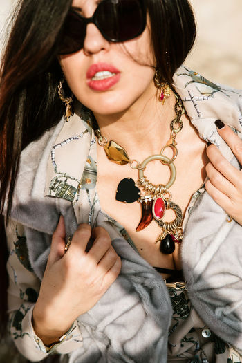 Closeup of young woman wearing sunglasses and jewelry