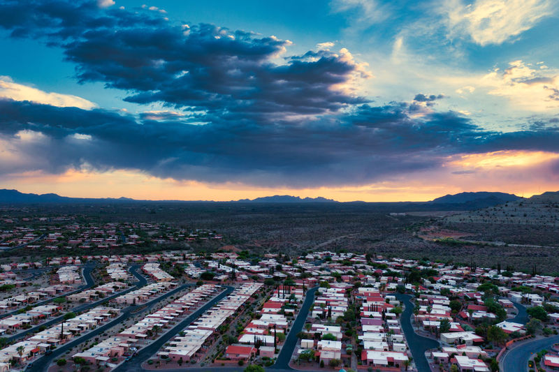 Rows of homes in green valley, arizona with vibrant clouds.