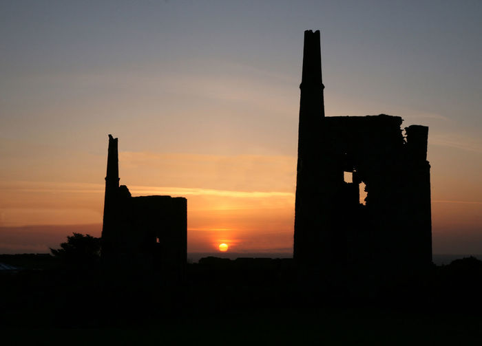 Low angle view of silhouette building against sky during sunset