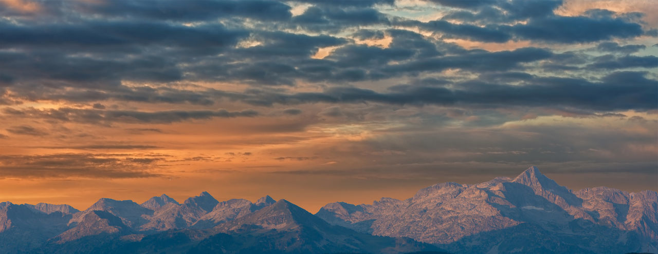 Scenic view of snowcapped mountains against dramatic sky