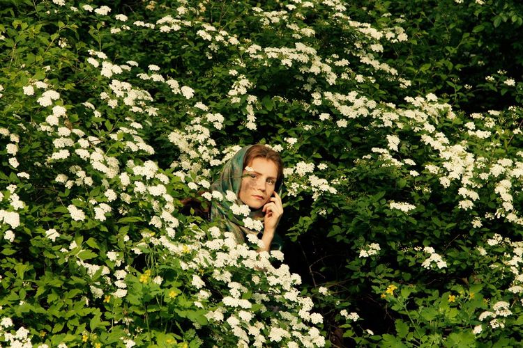 Close-up of young woman amidst flowers