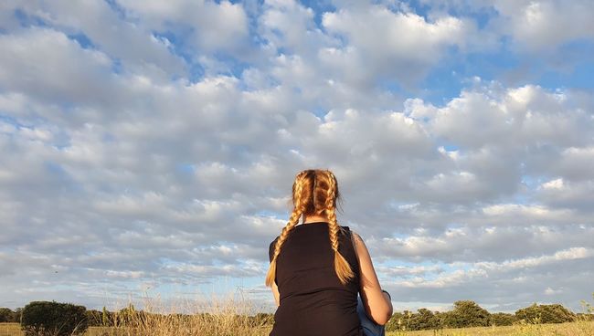 Rear view of woman standing against sky