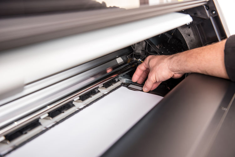 Cropped hand working in printing press