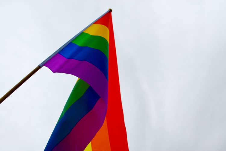 Low angle view of rainbow pride flag against sky