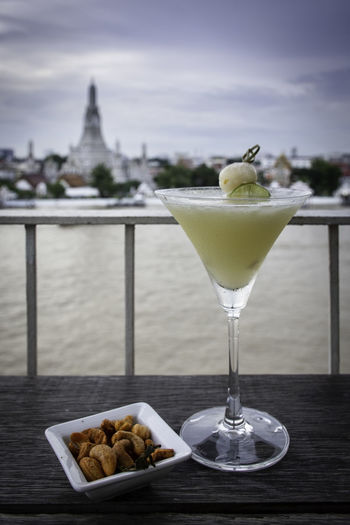 Chilling bar in bangkok at chao phraya riverside opposite wat arun with drink in the evening.