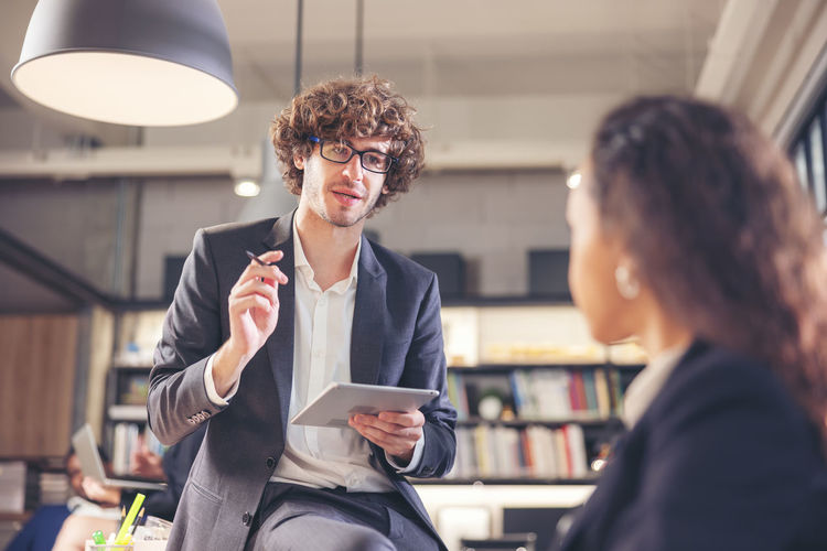 Colleagues in a boardroom discussion, seated at a table together,