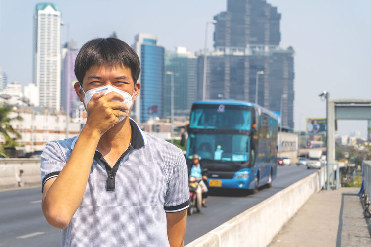 Portrait of man standing on street in city
