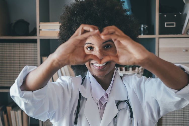 Doctor making heart gesture at clinic