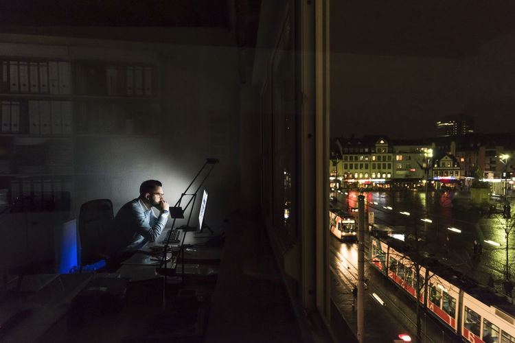 Businessman working on computer in office at night