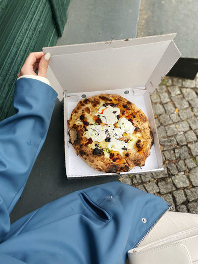 High angle view of hand holding pizza