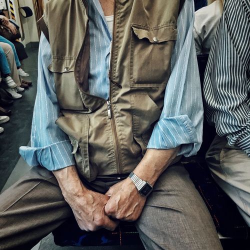 Midsection of man sitting in train