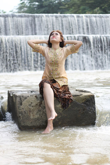 Full length of young woman looking at water