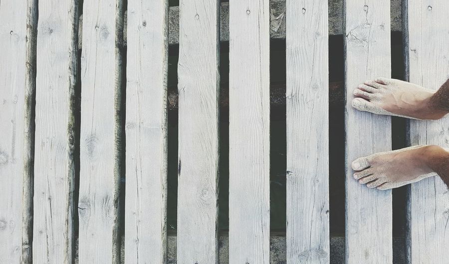 Low section of bare feet on wood paneling