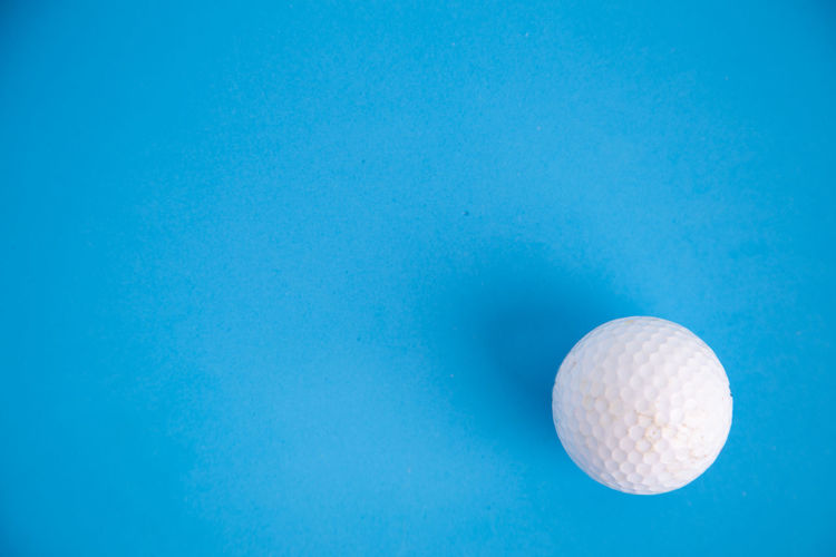 Directly above shot of golf ball over blue background