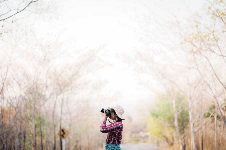 Low angle view of woman walking on field against sky