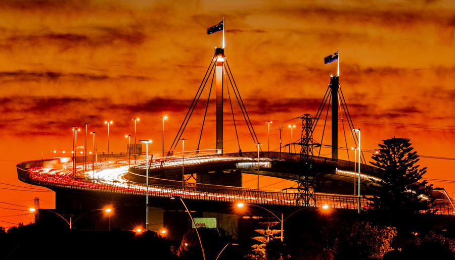 Illuminated bridge against sky in night