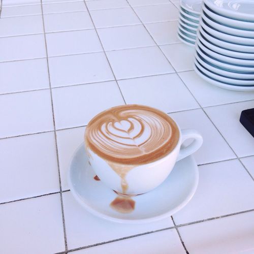 Close-up of coffee cup on tiled floor