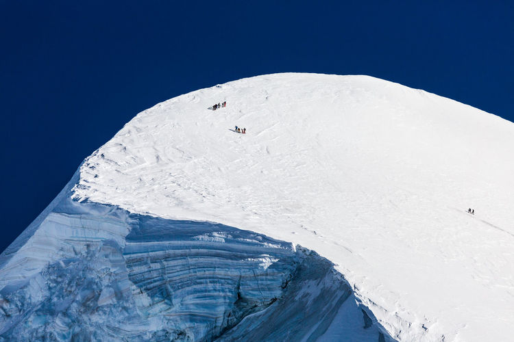 Aerial view of snowcapped mountain against blue sky. view from klein matterhorn, swiss alps