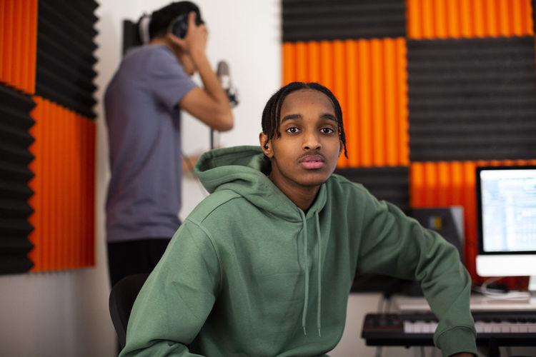 Teenage boy with dreads sitting in recording studio