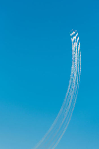 Low angle view of airplane flying against clear blue sky
