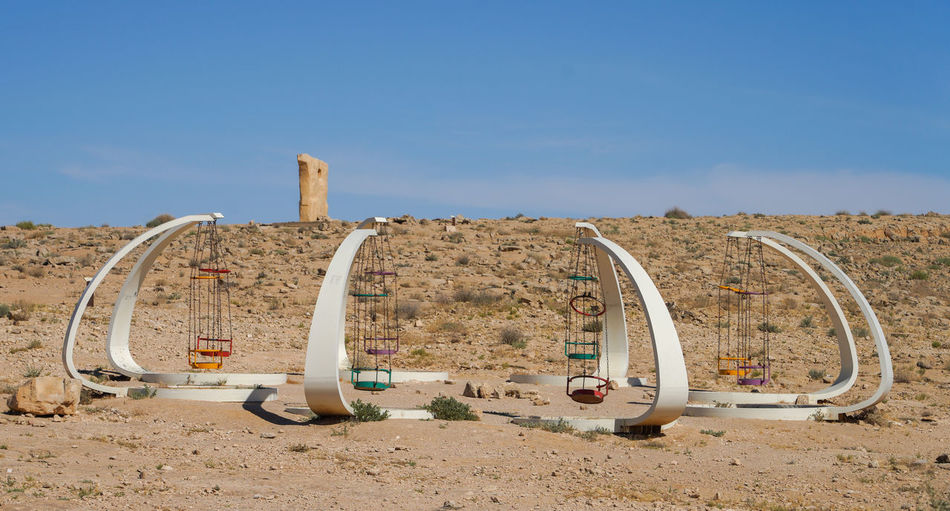 Metallic structure in desert against blue sky