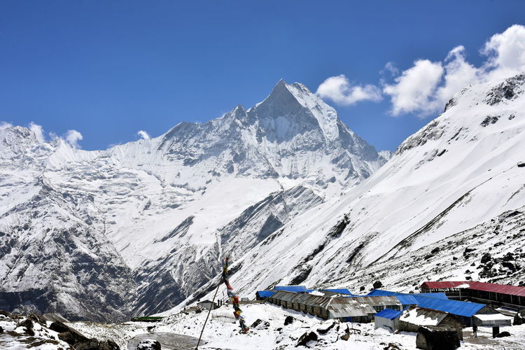 Scenic view of base camp and snowcapped mountains against sky