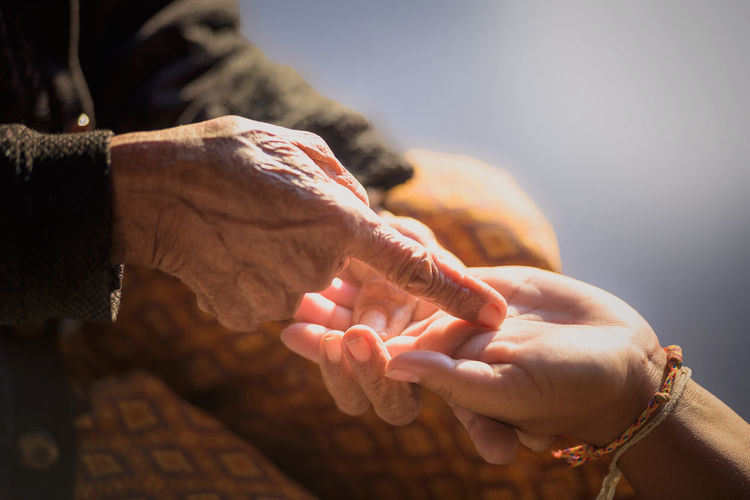 The hands of old women and young women, taking care of the elderly closely.