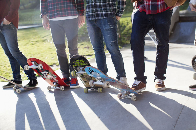 Low section of people standing on skateboard