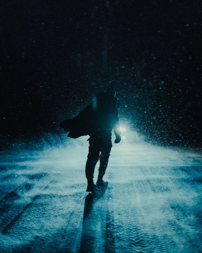Silhouette man walking on snow