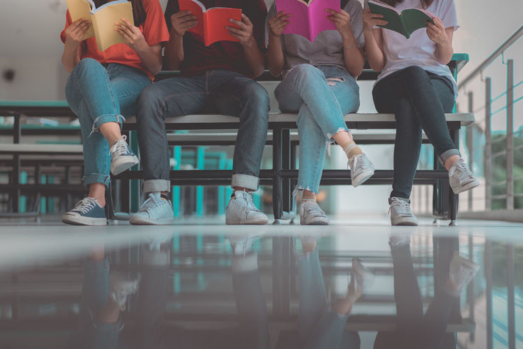 A group of asian students reading books.