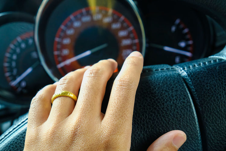 Close-up of hand driving car